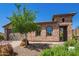 Close up of the front exterior with stone details, desert landscaping, arched windows, and gated entrance at 29703 N 70Th Ave, Peoria, AZ 85383