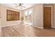 Bright living room featuring wood-look tile flooring, plantation shutters, and double French doors at 29703 N 70Th Ave, Peoria, AZ 85383