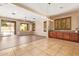 Open living space with tile and wood flooring, a built-in bar area, and sliding glass doors to the patio at 29703 N 70Th Ave, Peoria, AZ 85383