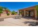 A covered patio with an outdoor dining set in a desert landscaped backyard at 29703 N 70Th Ave, Peoria, AZ 85383