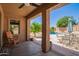 Covered patio offers views of the pool, outdoor seating, and lush landscaping for relaxation and entertainment at 29703 N 70Th Ave, Peoria, AZ 85383