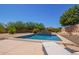 A sparkling pool with stone feature in a desert landscaped backyard with lounge chair on the patio at 29703 N 70Th Ave, Peoria, AZ 85383