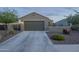Exterior view of a one-story home with a two-car garage, desert landscaping, and a long driveway at 3661 E Appaloosa Dr, San Tan Valley, AZ 85140