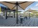 A community outdoor kitchen featuring grills, seating, shade structures, and paved patio at 3661 E Appaloosa Dr, San Tan Valley, AZ 85140