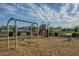 A community playground with swings, a slide, and other playground equipment on a wood chip surface at 3661 E Appaloosa Dr, San Tan Valley, AZ 85140