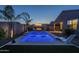 Stunning backyard pool features a sleek design with lounge chair, fire pit, and lush landscaping, ideal for relaxing evenings at 3661 E Appaloosa Dr, San Tan Valley, AZ 85140