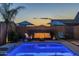Backyard pool and lounge area with outdoor seating and fire pit, perfect for relaxing evenings by the illuminated pool at 3661 E Appaloosa Dr, San Tan Valley, AZ 85140