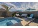 Backyard pool area with seating, umbrellas, palm trees, and desert landscaping at 3661 E Appaloosa Dr, San Tan Valley, AZ 85140