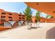 Balcony with tile flooring and seating, overlooking manicured grounds and the architecture of the community at 4303 E Cactus Rd # 202, Phoenix, AZ 85032