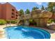 Beautiful pool with a rock waterfall feature and clear blue water at 4303 E Cactus Rd # 202, Phoenix, AZ 85032