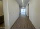 Bright hallway with wood-look tile flooring that leads to an open living space with natural light at 47219 W Pecan Woods --, Maricopa, AZ 85139