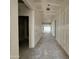 Interior view of a long hallway with fresh drywall, showcasing the home's layout and natural light at 47219 W Pecan Woods --, Maricopa, AZ 85139