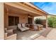 Relaxing covered back patio with seating, ceiling fan, and a private hot tub area at 4757 E Goldfinch Gate Ln, Phoenix, AZ 85044