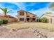 Backyard showcasing a covered patio, hot tub, desert landscaping, and blue skies at 4757 E Goldfinch Gate Ln, Phoenix, AZ 85044
