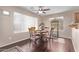 Bright dining room features hardwood flooring, light walls, a ceiling fan, and a dark wood dining set at 4757 E Goldfinch Gate Ln, Phoenix, AZ 85044