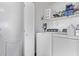 Functional laundry room featuring a white washer and dryer, storage shelves, and utility sink at 4757 E Goldfinch Gate Ln, Phoenix, AZ 85044