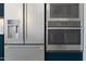 Close-up of stainless steel GE Profile appliances, including a refrigerator, microwave, and oven, in a modern kitchen at 491 E Aurora Dr, San Tan Valley, AZ 85140
