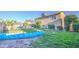 Spacious backyard with lush green grass, shade trees, a pool, and charming patio area at 538 E Rockwood Dr, Phoenix, AZ 85024
