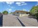 Open gravel backyard with a patio swing and yellow siding on the house at 7001 E Flossmoor Ave, Mesa, AZ 85208