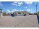 Spacious gravel backyard with yellow house and fence creating privacy at 7001 E Flossmoor Ave, Mesa, AZ 85208