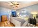 Comfortable bedroom featuring a ceiling fan, wood floors, and light blue paint at 7001 E Flossmoor Ave, Mesa, AZ 85208