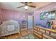 Inviting bedroom featuring a crib, dresser, and decorations on a purple wall at 7001 E Flossmoor Ave, Mesa, AZ 85208