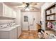 A functional laundry room equipped with a washer, dryer, and ample storage shelving at 7001 E Flossmoor Ave, Mesa, AZ 85208