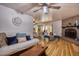 Bright living room featuring light wood floors, a fan and an open view to the dining area at 7001 E Flossmoor Ave, Mesa, AZ 85208