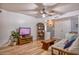 Comfortable living room featuring neutral walls, wood floors, and a wooden entertainment center at 7001 E Flossmoor Ave, Mesa, AZ 85208