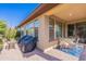 Charming backyard patio with seating area, surrounded by lush plants and a view of the home's exterior at 720 E Cobble Stone Dr, Queen Creek, AZ 85140