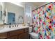 Cozy bathroom featuring colorful shower curtain, white counters, and brown cabinetry at 720 E Cobble Stone Dr, Queen Creek, AZ 85140