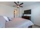 Bedroom with a ceiling fan, TV, dark wood dresser, and a view of the hallway and entrance at 720 E Cobble Stone Dr, Queen Creek, AZ 85140