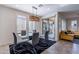 Sunlit dining area with a glass table, stylish chairs, and sliding door access to patio at 720 E Cobble Stone Dr, Queen Creek, AZ 85140