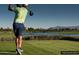 Scenic golf course view with a golfer, lush greens, and a tranquil lake backdrop at 720 E Cobble Stone Dr, Queen Creek, AZ 85140
