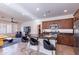 Bright kitchen with wooden cabinetry, stainless appliances, granite counters, and bar seating adjacent living area at 720 E Cobble Stone Dr, Queen Creek, AZ 85140