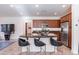 Bright kitchen with wooden cabinetry, stainless appliances, granite counters, and bar seating at the island at 720 E Cobble Stone Dr, Queen Creek, AZ 85140