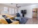 Comfortable living room featuring a modern ceiling fan, large windows, stylish sofa, and entertainment area at 720 E Cobble Stone Dr, Queen Creek, AZ 85140