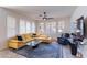 Bright living room with shuttered windows, ceiling fan, stylish sectional, and glass coffee table at 720 E Cobble Stone Dr, Queen Creek, AZ 85140