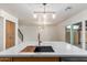Modern kitchen island featuring wood accents, an undermount sink, and modern pendant lighting at 7647 E Montecito Ave, Scottsdale, AZ 85251