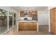 Bright kitchen with a waterfall countertop island, stainless appliances, and stylish light fixtures at 7647 E Montecito Ave, Scottsdale, AZ 85251