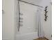 Bathroom featuring a shower and tub combination with white tile, and metal shelving at 7844 W Jenan Dr, Peoria, AZ 85345