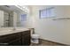 Bright bathroom featuring a dark wood vanity and a large mirror and window to add natural light at 7844 W Jenan Dr, Peoria, AZ 85345