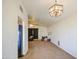 Open living room features neutral carpet, light fixture, and view of kitchen appliances at 7844 W Jenan Dr, Peoria, AZ 85345