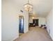 Open living room features neutral carpet, light fixture, and view of kitchen appliances at 7844 W Jenan Dr, Peoria, AZ 85345