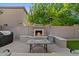 Cozy backyard patio with an outdoor fireplace, seating, and desert landscaping at 834 W Whitten St, Chandler, AZ 85225