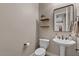 Neat half bath showcasing pedestal sink, toilet, and decorative shelving at 834 W Whitten St, Chandler, AZ 85225