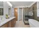 Modern bathroom with double vanity, sleek fixtures, glass-enclosed shower, and freestanding tub at 834 W Whitten St, Chandler, AZ 85225