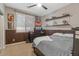 Comfortable bedroom featuring a ceiling fan, a window with blinds, decor shelves and paneled walls at 834 W Whitten St, Chandler, AZ 85225