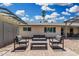 Comfortable backyard seating area on a stone patio with lush landscaping and shade coverings at 855 S Revolta Cir, Mesa, AZ 85208