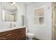 Bright bathroom featuring a wooden vanity, modern gold fixtures, and a neutral color scheme at 855 S Revolta Cir, Mesa, AZ 85208